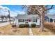 Charming home with tidy landscaping, front porch, and red front door at 2002 Fisher Ave, Indianapolis, IN 46224