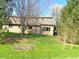 Rear exterior of house, featuring horizontal siding, mature trees and well-maintained lawn at 226 Sandbrook Cir, Noblesville, IN 46062