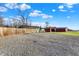A gravel area and outbuildings in a large backyard, under a sunny blue sky at 3011 S 550 W, Columbus, IN 47201