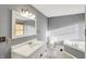 Well-lit bathroom featuring a soaking tub, toilet, and vanity with a large mirror at 3011 S 550 W, Columbus, IN 47201