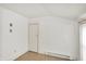 An empty room with white walls and trim, baseboard heat, and a wood-look floor at 3011 S 550 W, Columbus, IN 47201