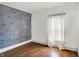 Bedroom with light hardwood flooring, stylish brick wall, and a window with bright light at 3011 S 550 W, Columbus, IN 47201