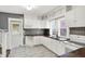 Bright and airy kitchen featuring white cabinetry, modern appliances, and unique backsplash, with access to backyard at 3011 S 550 W, Columbus, IN 47201