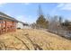 The spacious backyard has a combination of grass and dry foliage and is surrounded by a white picket fence at 3121 River Birch Dr, Indianapolis, IN 46235