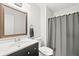 This bathroom features a vanity with a dark cabinet, a large mirror, and a shower with a gray shower curtain at 3121 River Birch Dr, Indianapolis, IN 46235