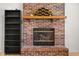 Close-up view of a brick fireplace with a wooden mantel, complementing the hardwood floors at 3121 River Birch Dr, Indianapolis, IN 46235