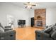 Open-concept living room with a brick fireplace, vaulted ceiling, and hardwood floors at 3121 River Birch Dr, Indianapolis, IN 46235