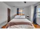 Inviting bedroom featuring hardwood floors, white walls, a ceiling fan, and natural light at 3416 Guilford Ave, Indianapolis, IN 46205