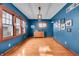 Dining room with hardwood floors, blue walls, natural light, and modern light fixture at 3416 Guilford Ave, Indianapolis, IN 46205