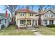 Two-story home with a red roof, tan siding, a welcoming front porch, and a well-manicured front lawn at 3416 Guilford Ave, Indianapolis, IN 46205