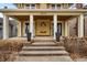 Inviting front porch with white pillars, dark planters, and a unique arch design on the facade at 3416 Guilford Ave, Indianapolis, IN 46205