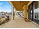 Spacious porch with white pillars, a wood ceiling, dark door and stylish exterior lighting at 3416 Guilford Ave, Indianapolis, IN 46205