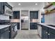 Spacious kitchen with black cabinets, stainless steel appliances, tile backsplash, and modern lighting at 3416 Guilford Ave, Indianapolis, IN 46205