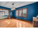 Charming living room featuring hardwood floors, blue accent walls, wood trim, and a modern light fixture at 3416 Guilford Ave, Indianapolis, IN 46205