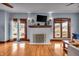 Bright living room featuring hardwood floors, a white fireplace, a ceiling fan, and multiple windows at 3416 Guilford Ave, Indianapolis, IN 46205