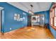 Bright living room with hardwood floors, blue accent wall, French doors, and modern light fixture at 3416 Guilford Ave, Indianapolis, IN 46205