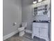 Powder bathroom featuring a white vanity, decorative mirror, and modern fixtures, and wood-look flooring at 4034 W 700 S, Shelbyville, IN 46176
