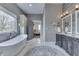 This gray bathroom features dual vanity, soaking tub, and access to bedroom at 4034 W 700 S, Shelbyville, IN 46176