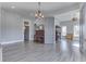 Open-concept living room with wood-look floors, modern chandelier and fireplace, and neutral paint at 4034 W 700 S, Shelbyville, IN 46176