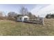 Rustic outbuilding with an attached outdoor enclosure on grassy property, perfect for a hobby farm at 4034 W 700 S, Shelbyville, IN 46176