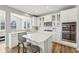 Bright kitchen with white cabinetry, stainless appliances, an island with bar stools, and a subway tile backsplash at 4905 Andover Pkwy, Westfield, IN 46062