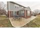 Back patio featuring outdoor dining set, brick accents, and well-maintained lawn with privacy fence at 5328 Kidwell Cir, Indianapolis, IN 46239