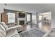 Spacious living room with a fireplace, dark laminate flooring, and natural light from large windows at 5328 Kidwell Cir, Indianapolis, IN 46239