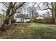 Spacious backyard with lush lawn, mature trees, patio furniture, and a swing set, perfect for outdoor enjoyment at 5432 Winthrop Ave, Indianapolis, IN 46220
