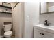 Functional bathroom featuring a toilet, tiled shower, floating shelves, and a vanity with modern black fixtures at 5432 Winthrop Ave, Indianapolis, IN 46220