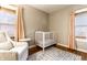 Cozy Bedroom featuring a white crib, comfortable chair, stylish rug, and soft natural light, creating a serene atmosphere at 5432 Winthrop Ave, Indianapolis, IN 46220