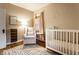 Bright Bedroom with a comfy chair, crib, hardwood floors, decor and large window, creating a warm and inviting space at 5432 Winthrop Ave, Indianapolis, IN 46220