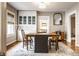 Bright dining room with hardwood floors, a large table, and a built-in glass cabinet for storage at 5432 Winthrop Ave, Indianapolis, IN 46220