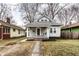 Inviting two-story home featuring a welcoming porch with a swing, complemented by a brick pathway at 5432 Winthrop Ave, Indianapolis, IN 46220