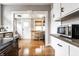 Bright kitchen boasts hardwood floors, stainless steel appliances, and neutral tones, with a view into the mudroom at 5432 Winthrop Ave, Indianapolis, IN 46220