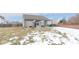 Wide view of backyard with patio featuring a metal pergola over outdoor seating, grill, and winter grass at 5443 Alcott Ln, Indianapolis, IN 46221