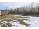 Wide view of backyard with fencing, small trampoline, winter grass, and a cozy patio at 5443 Alcott Ln, Indianapolis, IN 46221