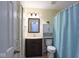 Inviting bathroom with dark wood vanity, toilet and a decorative shower curtain at 5443 Alcott Ln, Indianapolis, IN 46221