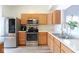 Modern kitchen with stainless steel appliances, light wood cabinets, and ample counter space for cooking at 5443 Alcott Ln, Indianapolis, IN 46221
