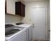 Efficient laundry area with front load washer and dryer, storage cabinets, and a door leading outside at 5443 Alcott Ln, Indianapolis, IN 46221