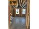 Interior of home featuring stud framing, unfinished ceiling, and two windows in the early stages of construction at 5740 Birtz Rd, Lawrence, IN 46216