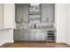 Stylish bar area features custom cabinets, stone backsplash, open shelving, stainless steel beverage fridge at 580 Exmoor Dr, Carmel, IN 46032