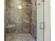 Close-up of tiled walk-in shower with a herringbone-patterned floor at 580 Exmoor Dr, Carmel, IN 46032