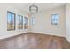 An empty bedroom featuring wood floors, large windows with black trim, and modern lighting at 580 Exmoor Dr, Carmel, IN 46032