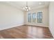 Bedroom boasts hardwood floors, a tray ceiling, large windows, and modern chandelier for natural light at 580 Exmoor Dr, Carmel, IN 46032