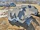 New home construction shows a light-colored exterior, gray roof, and a backyard with a concrete patio at 580 Exmoor Dr, Carmel, IN 46032