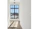 Sunlit hallway with wood floors featuring a large black trimmed window and natural light at 580 Exmoor Dr, Carmel, IN 46032