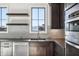 Modern kitchen featuring dark wood cabinets, stainless steel appliances, and stylish countertops, plus floating shelves at 580 Exmoor Dr, Carmel, IN 46032