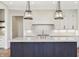 A gourmet kitchen features an island with marble countertop and statement pendant lights at 580 Exmoor Dr, Carmel, IN 46032