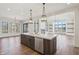 Open-concept kitchen showcasing an island, hardwood floors, stainless steel appliances, and natural light at 580 Exmoor Dr, Carmel, IN 46032