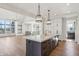 Kitchen features an island, modern light fixtures, and view of the open concept living space at 580 Exmoor Dr, Carmel, IN 46032